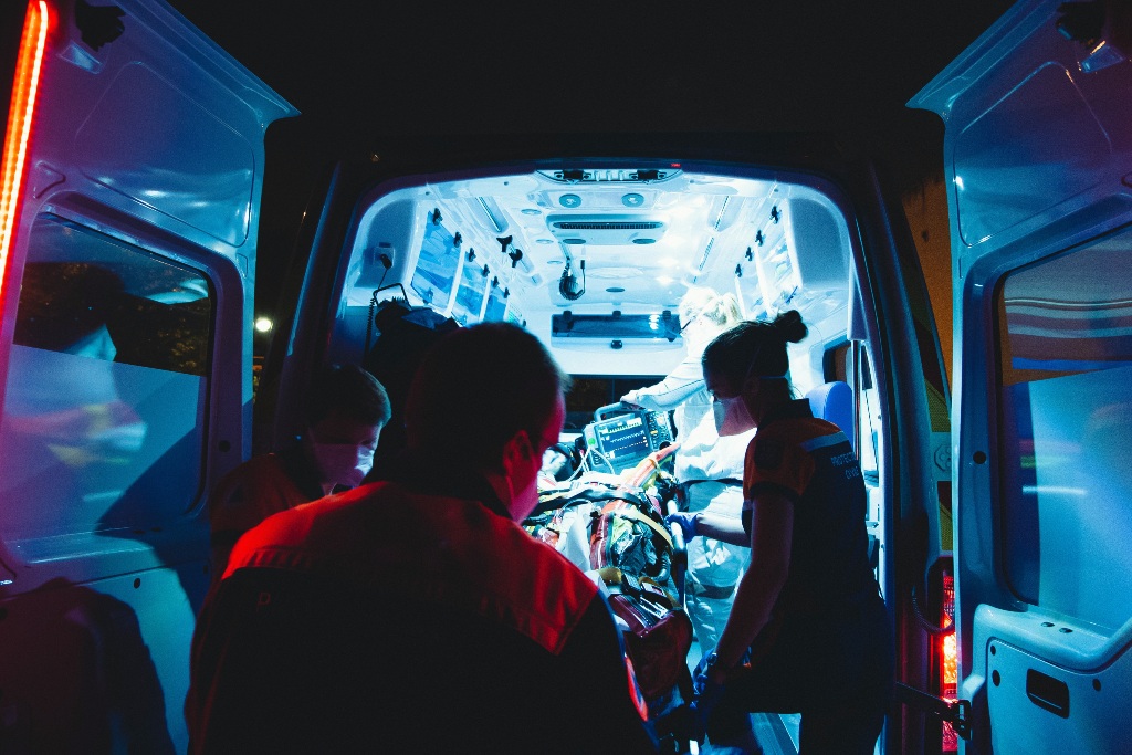 An emergency medical team working with a patient in the back of an ambulance.