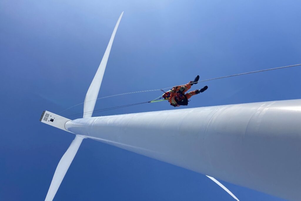 A rope rescue person descending from a wind power turbine in Canada